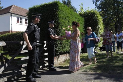 Un grupo de personas llevan flores a la casa de la familia británica asesinada en Francia.