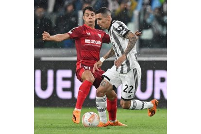 Oliver Torres pugna por el control del balón con Di María. SOCCER