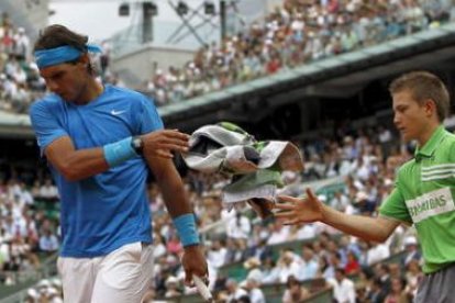 Nadal, con gesto de preocupación por su juego irregular, devuelve la toalla al recogepelotas.