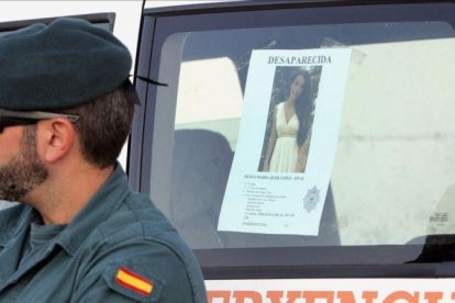 Un guardia civil con la foto que se ha distribuido de Diana Quer.