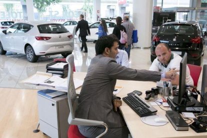 Un cliente de un concesionario de coches pide información.