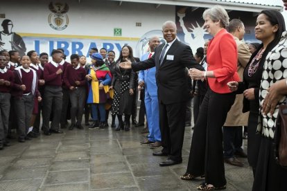 Theresa May, durante su visia a una escuela de Ciudad del Cabo, donde se ha arrancado a bailar. /