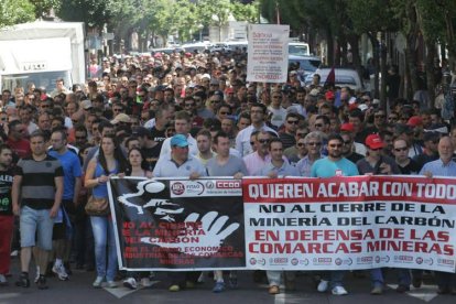 Dos mineros muestran su apoyo a los encerrados asomados a la ventana del despacho del PSOE en el Palacio de los Guzmanes.