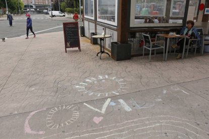 Una pintada referente a la Covid19 en la acera donde se sitúa la terraza de un establecimiento hostelero de León, en la fase 3 de desescalada. F. Otero Perandones.