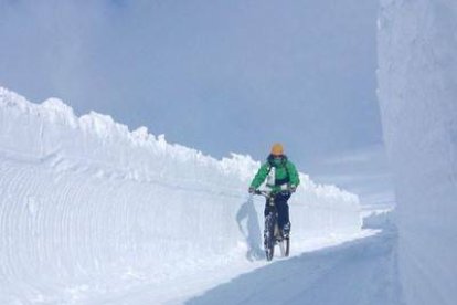 Jorge, monitor de snowboard en San Isidro, se da un paseo en bici en un pasadizo abierto en la estación