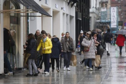 La lluvia no desanimó a los leoneses, que ‘cargaron’ prendas con rebaja en las tiendas. FERNANDO OTERO