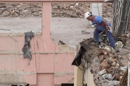 Un trabajador con arnés de protección pero sin anclar, en una obra