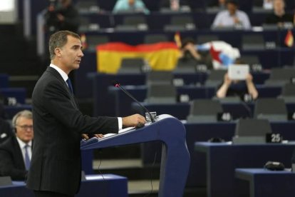 El rey Felipe, durante su discurso, con una bandera republicana y una independentista gallega al fondo, este miércoles en el Parlamento Europeo.