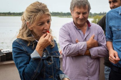 Yolanda Díaz prueba una de las fresas que le han ofrecido algunos de los agricultores de la aldea del Rocío. JULIÁN PÉREZ