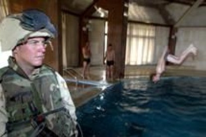 Un marine vigila el baño de dos colegas en la lujosa piscina que Sadam tenía en su palacio de Tikrit