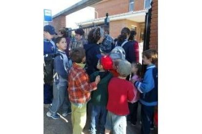 Los niños se arremolinaron detrás de la puerta del colegio