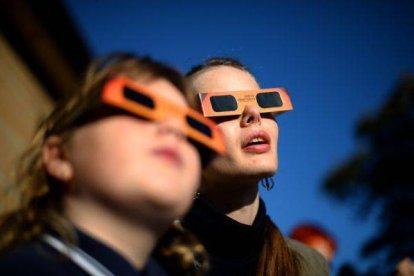 Una mujer y una niña contemplan un eclipse parcial de sol, en Sídney, en mayo del 2013.