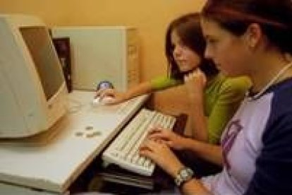 Dos jóvenes, navegando por Internet en un ciber de León