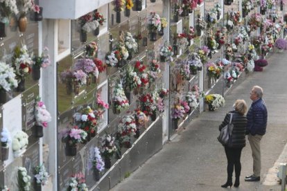 Dos personas junto al nicho familiar en el cementerio de Ponferrada. L. DE LA MATA