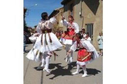 Cuatro danzantes de la Virgen ejecutan uno de los pasos del paloteo