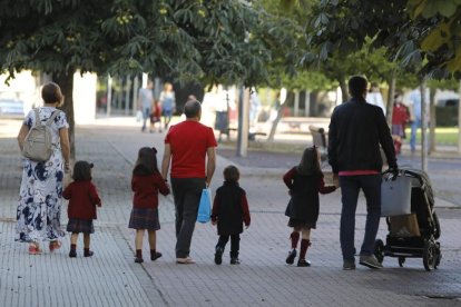 Una padres llevan a sus hijos al colegio en León.