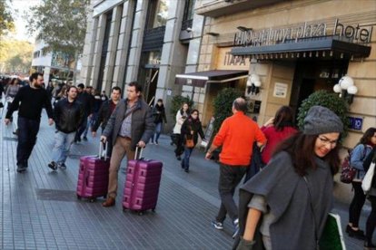 Viandantes cerca de un hotel en la plaza de Cataluña de Barcelona.