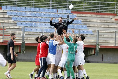 Los jugadores de la Cultural B mantean a su entrenador David Bandera celebrando el ascenso. MARCIANO