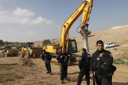 Policías israelís montan guardia junto a excavadoras tras demoler las casas del poblado beduino de Um al Hiran, este miércoles.