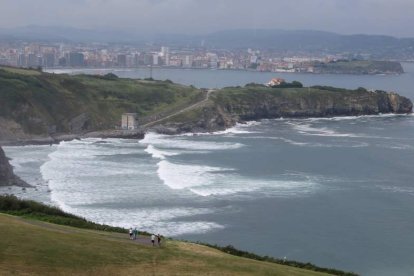 Vista desde el mirador, con Gijón al fondo. Y sobre estas líneas, el Mirador de La Providencia, un rincón de arte y paisaje es un remanso para la contemplación; y el monumento «Nunca Más» próximo a los acantilados.