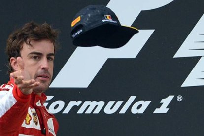 Fernando Alonso lanza la gorra al público desde el podio del GP de Bélgica.