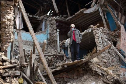 Un hombre en pie entre las runas de un edificio destruido por el terremoto de Nepal.