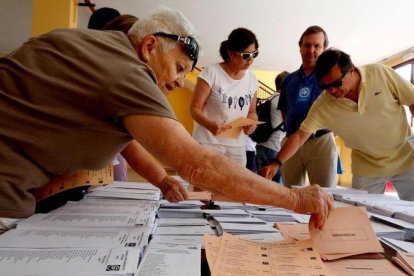 Votantes eligen papeletas en un colegio electoral de Madrid en las elecciones generales del 26 de junio de 2016.