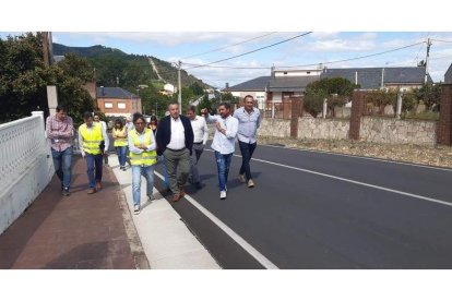 Morán, en el centro, escucha las explicaciones de un técnico sobre la carretera. DL