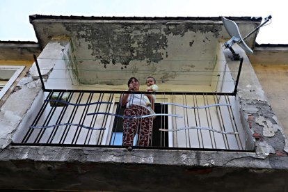 Augusta Rodrígues, con su hijo pequeño, en el balcón de su casa en El Escobio