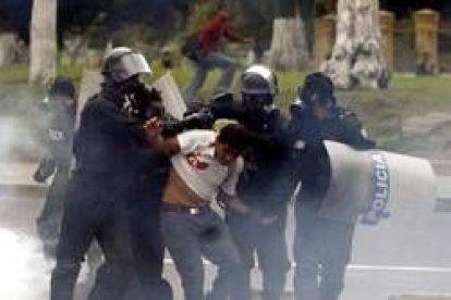 Un manifestante es arrestado por varios policías en Quito