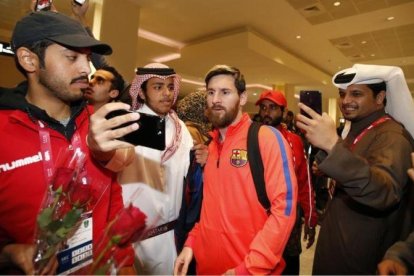 Aficionados catarís se hacen fotos con Messi en el aeropuerto de Doha.