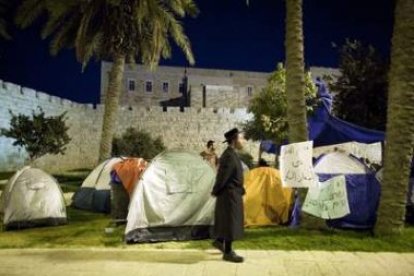 Un judío ultraortodoxo camina mirando «la ciudad campamento» en Jerusalén.