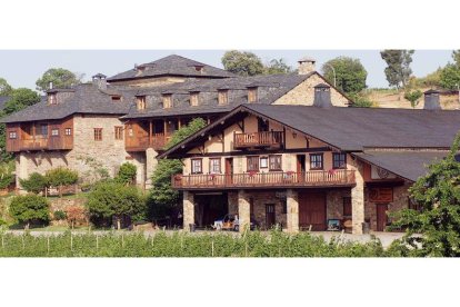 Impresionante imagen de la bodega en primer plano, con el palacio de Canedo al fondo y el viñedo recibiendo al visitante.