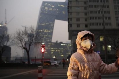 Una niña con una máscara protectora para la contaminación en Pekín, este lunes.