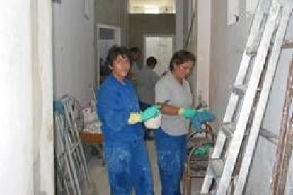 En primer plano, alumnas del taller de empleo en las obras de las instalaciones deportivas