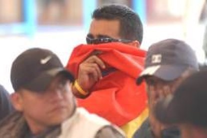 Un paramilitar se tapa el rostro para no ser reconocido en el acto de entrega de indultados