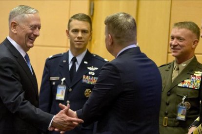 Jim Mattis conversa con miembros de su delegación antes del comienzo de la cumbre.