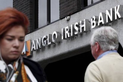 Dos viandantes pasan por delante de una agencia del Anglo Irish Bank, en Dublín, en septiembre del 2010.