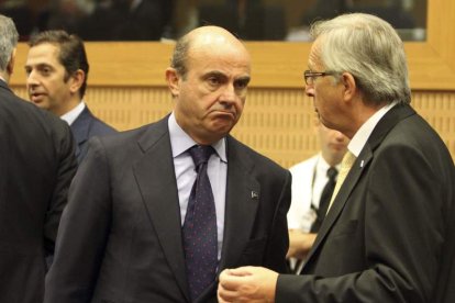 Luis de Guindos conversa con el presidente del Eurogrupo, Jean-Claude Juncker, durante la reunión.