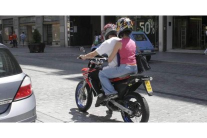 Dos jóvenes circulan en motocicleta por la avenida de Ordoño II de la capital. PABLO