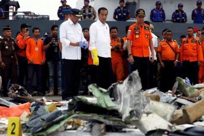 El presidente indonesio, Joko Widodo (centro), inspecciona algunos de los restos del avión de Lion Air siniestrado.