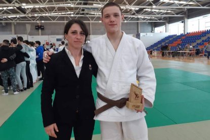 Pablo Fernández posa con el trofeo junto a su entrenadora Sara Terán.