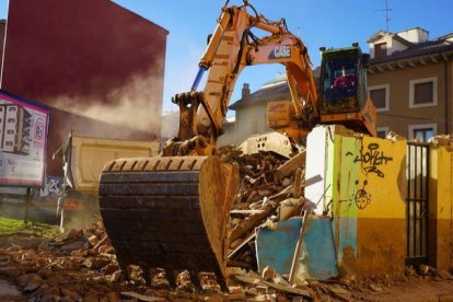 La retroexcavadora acabó este sábado con las dos casas junto a las que se levantará un nuevo edificio, como anuncia el cartel. J. NOTARIO