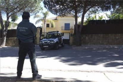 Un agente de la Guardia Civil custodia el exterior del domicilio donde se han encontrado los cadáveres.