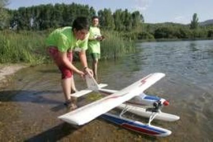 Participantes en la concentración se disponen a hacer despegar uno de los hidroaviones sobre el lago