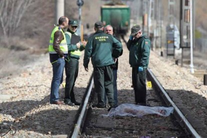 Agentes de la Guardia Civil y personal del Adif, conversan tras haber inspeccionado la vía.