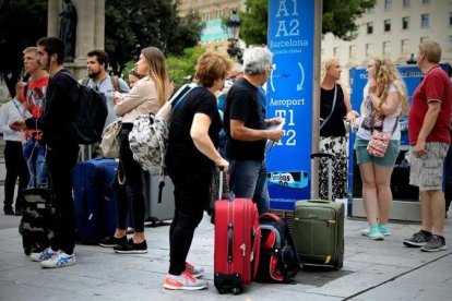 Turistas esperando el Aerobus en la Plaza Cataluña.