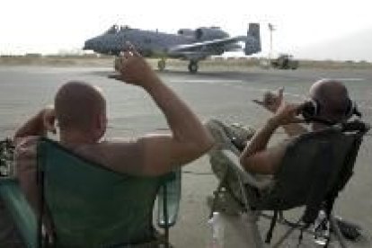 Los soldados Jay Charlebois y Sven Berger descansan ante su avión en una base de Oriente Medio