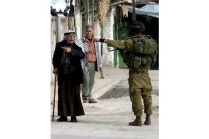 Un soldado judío indica a un anciano palestino la dirección prohibida