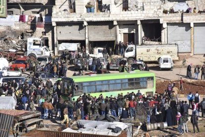 Civiles, combatientes y sus familiares acceden a uno de los autobuses durante la evacuación. EFE